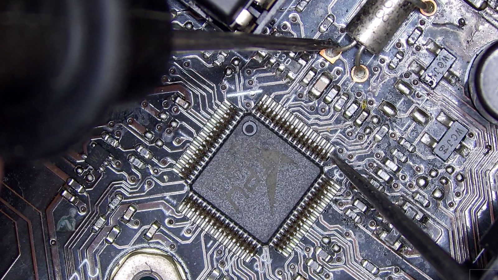 Multimeter probes measuring resistance at a crystal oscillator on a circuit board, indicating potential signal failure during diagnostic testing