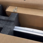 Brand new all-in-one computer inside its original box with packaging materials visible before initial setup and configuration