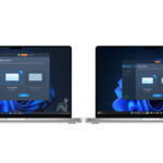 Two laptops placed side by side with a visible data transfer in progress, indicating files being moved directly between systems