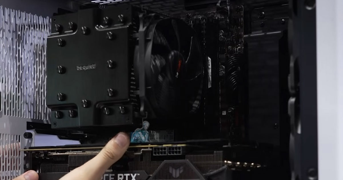Technician removing a desktop graphics card from the motherboard during diagnostic testing to identify hardware-related issues