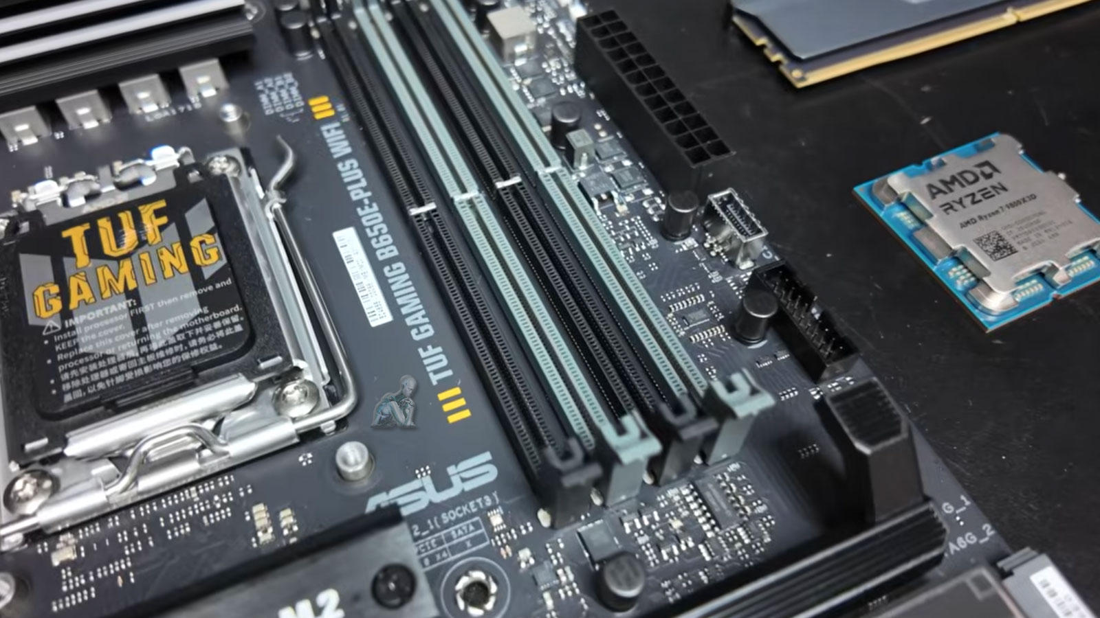 ASUS TUF Gaming motherboard with AMD Ryzen processor and RAM modules arranged for a custom gaming PC build