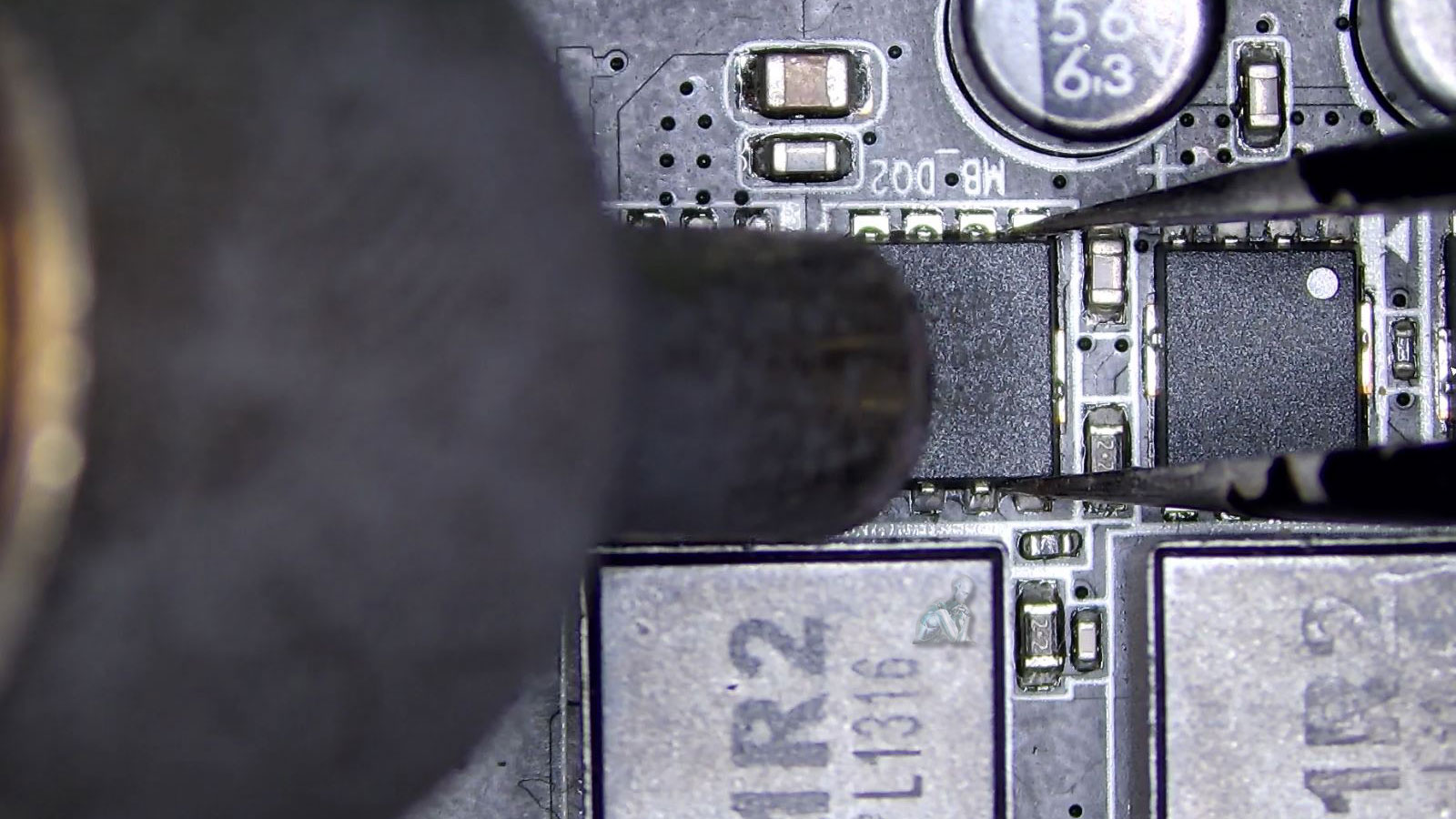 Technician using a hot air rework station to remove a damaged component from a drone circuit board during repair