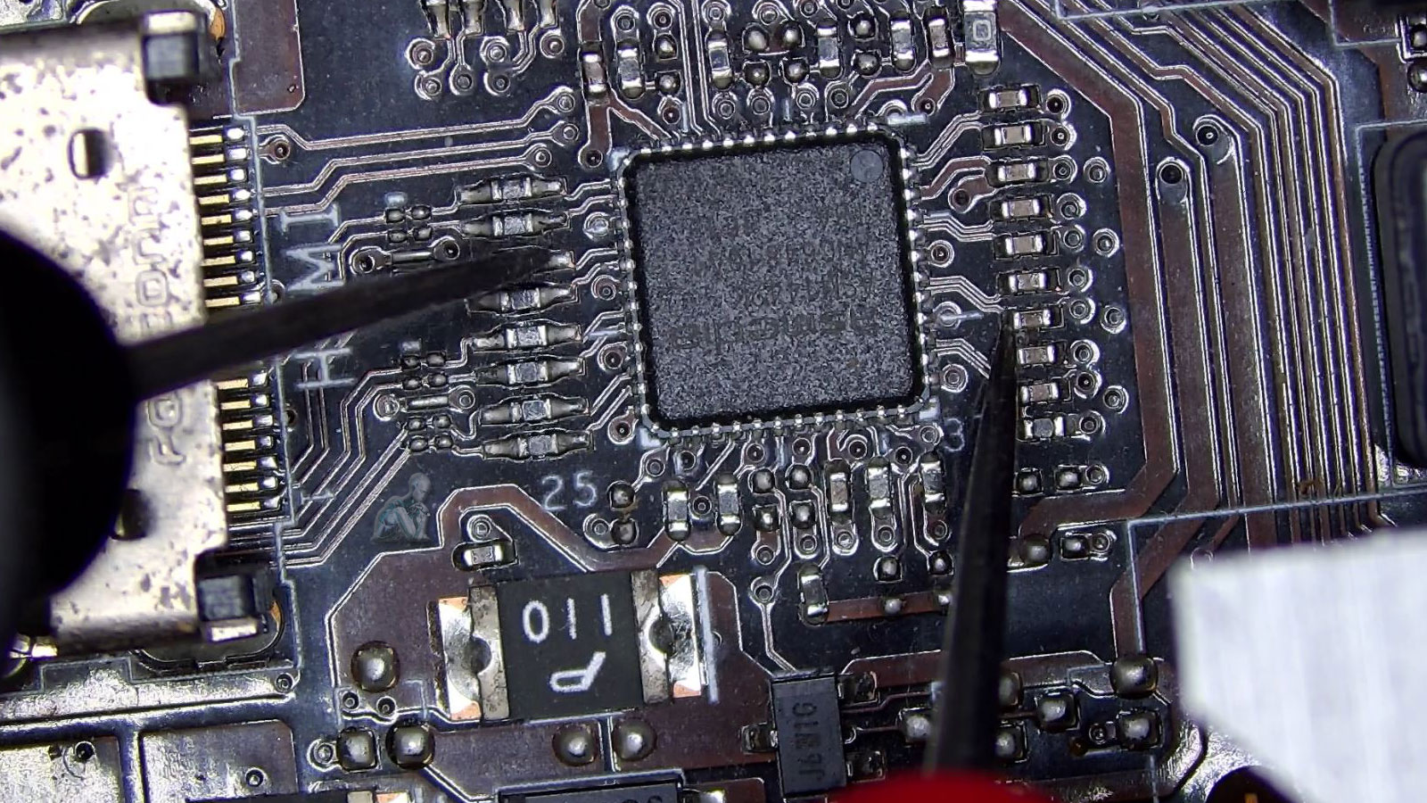Multimeter probes touching circuit points on a gaming PC motherboard to analyze electrical signals during diagnostic testing