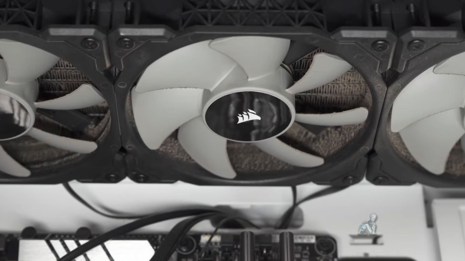 CPU cooling radiator with three attached fans covered in dust and debris being cleaned to restore airflow in a gaming PC system