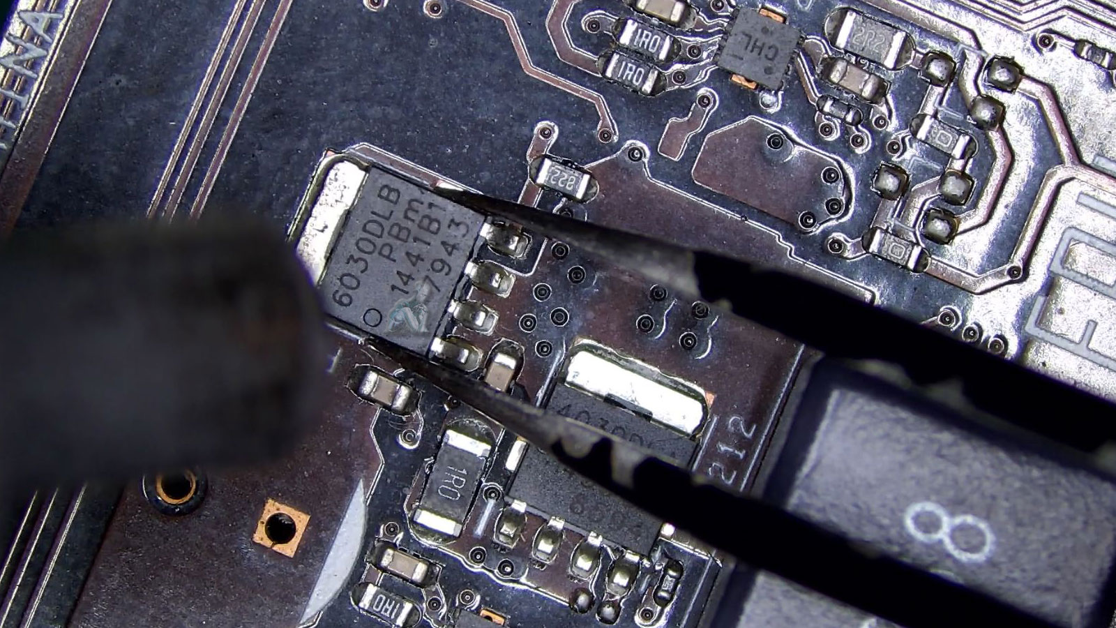 Technician using a hot air rework station to remove a damaged component from a GPU during board-level repair