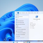 Laptop screen showing Windows 11 setup nearing completion with a PowerShell window open for configuration commands