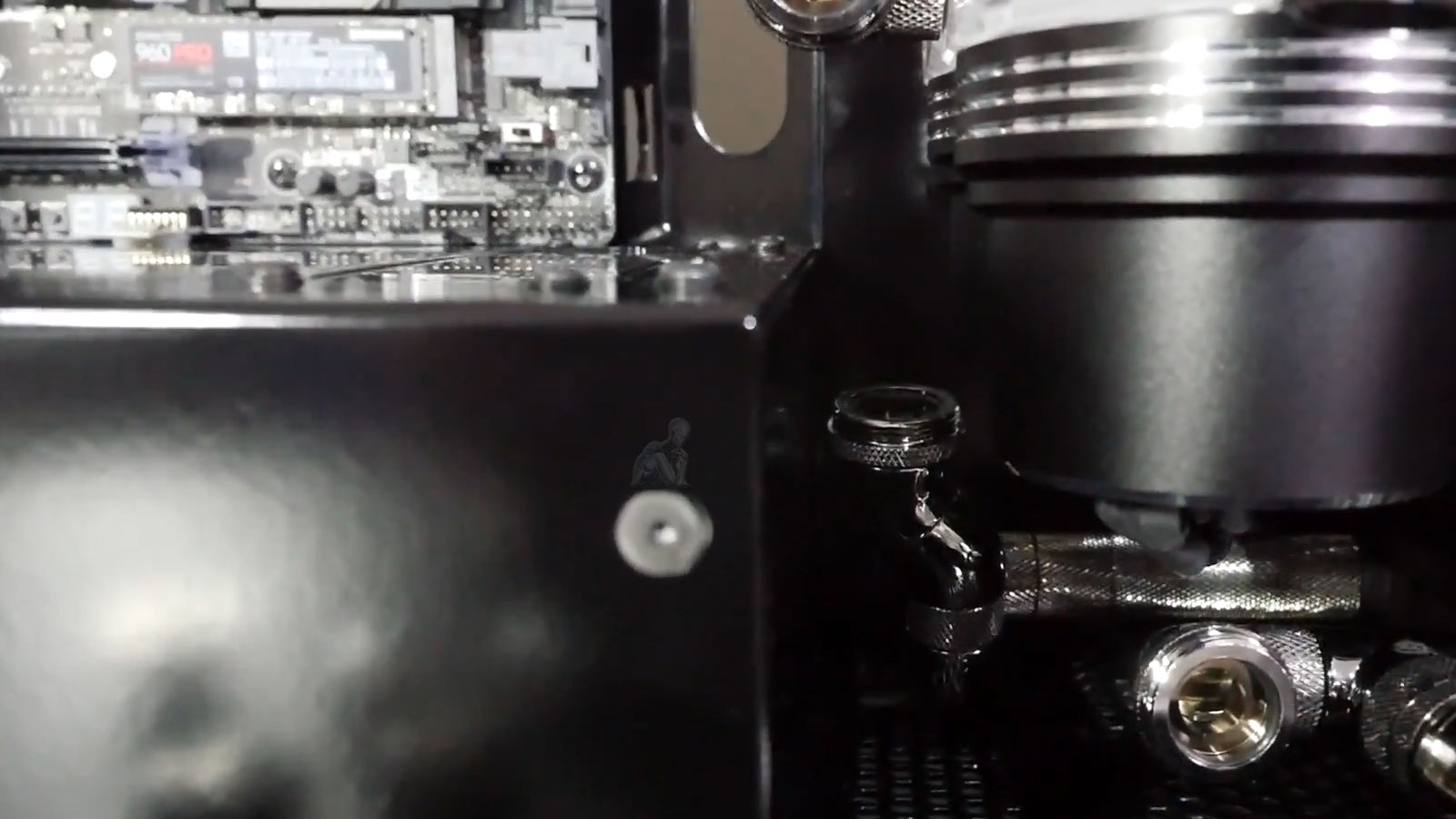 Custom-built PC with hard tube liquid cooling system open during repair, showing fittings being removed after a water leak