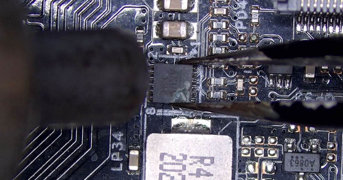 Comprehensive-Computer-Repair-Solutions-for-Systems-in-Medley-FL Close-up of a technician using precision tools to remove a damaged SMD component from a motherboard, exposing solder pads and surrounding microelectronics