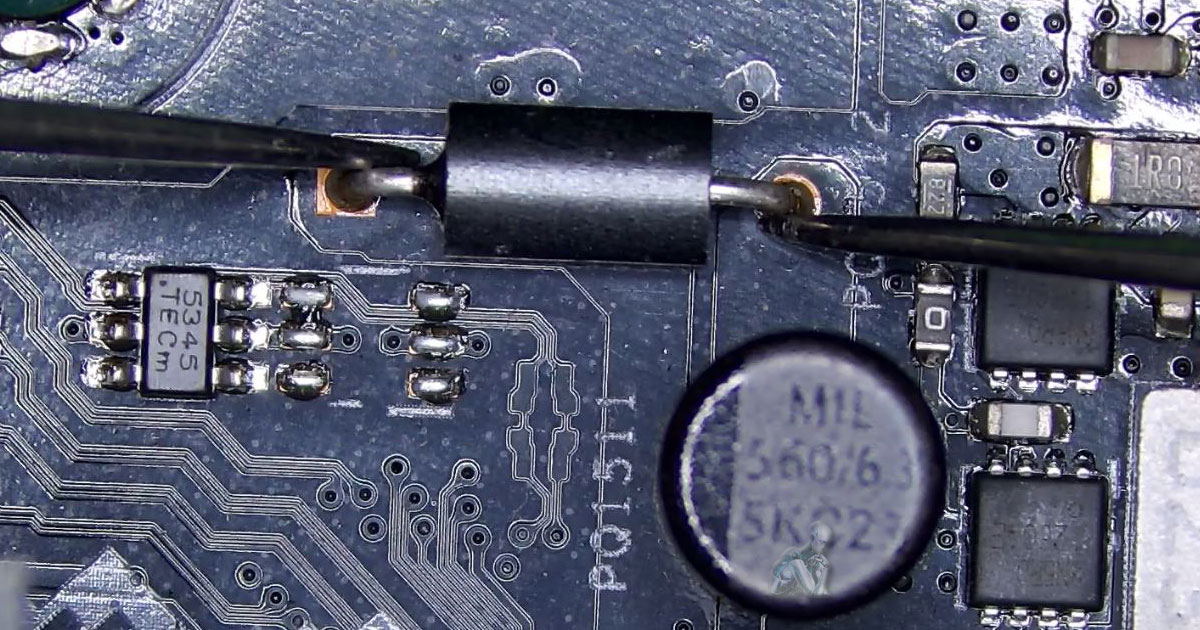 Magnified section of a circuit board where multimeter probes are placed across a diode to evaluate its condition, with adjacent components and solder joints visible