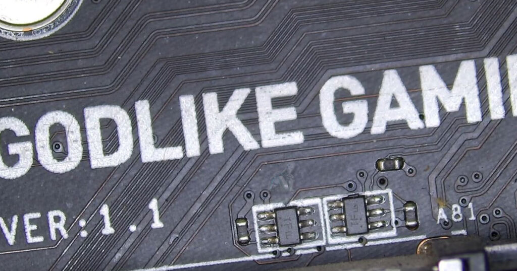 Gaming motherboard with a small TFIC chip showing visible damage near dense surface-mounted components and power regulation area