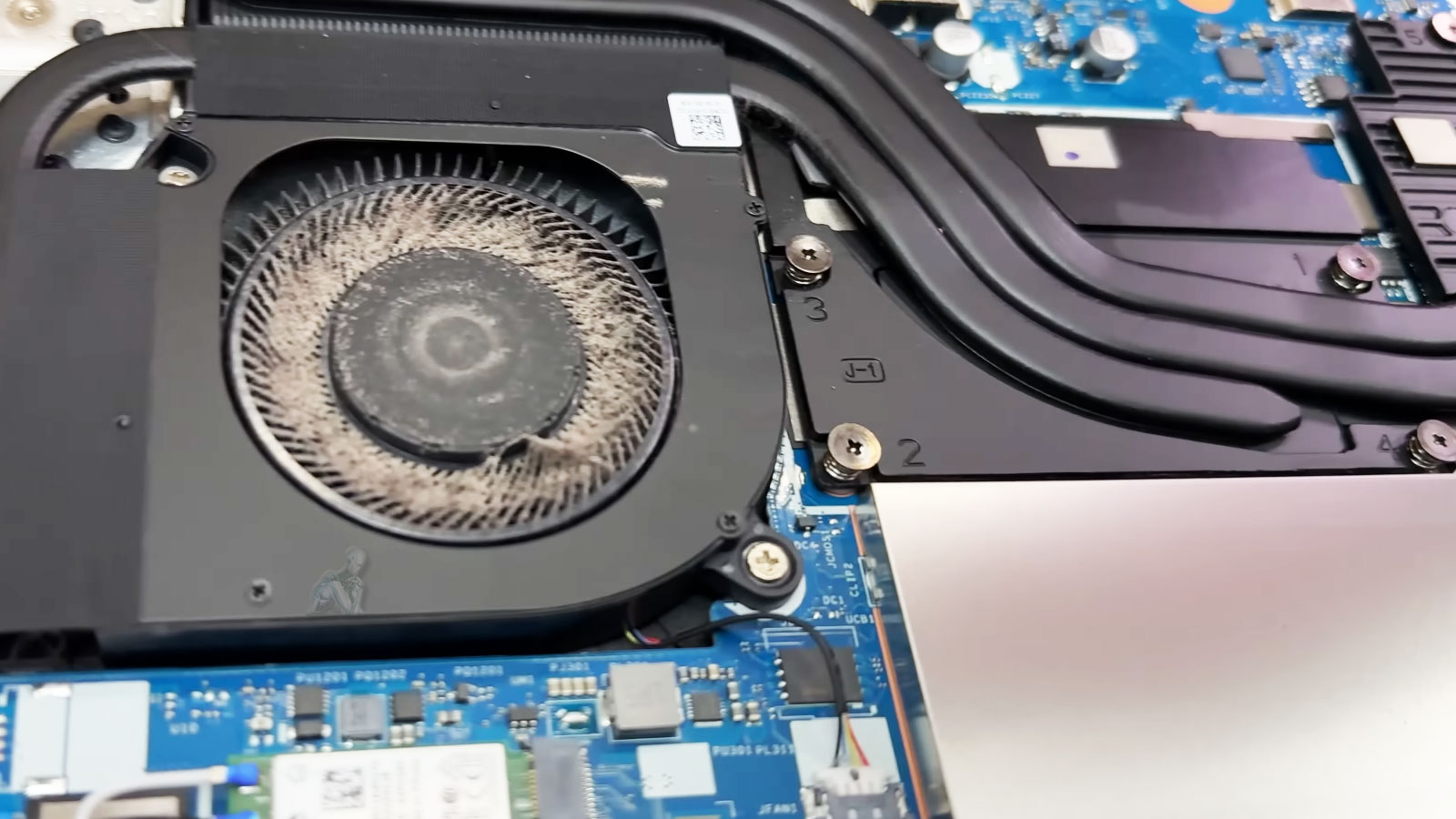 Laptop cooling fan heavily clogged with dust causing restricted airflow and overheating issues