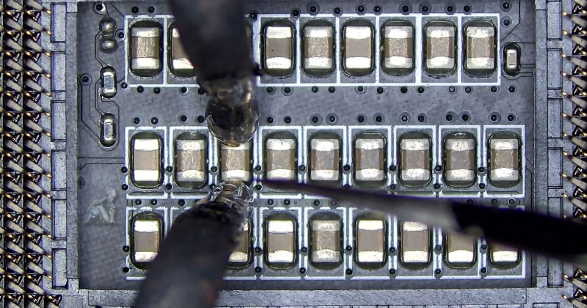 Computer-Repair-Services-Available-Near-You-for-Hardware-Issues Detailed board view of a CPU socket area where a faulty component is being removed, with visible pin grid, surrounding capacitors, and exposed contact points