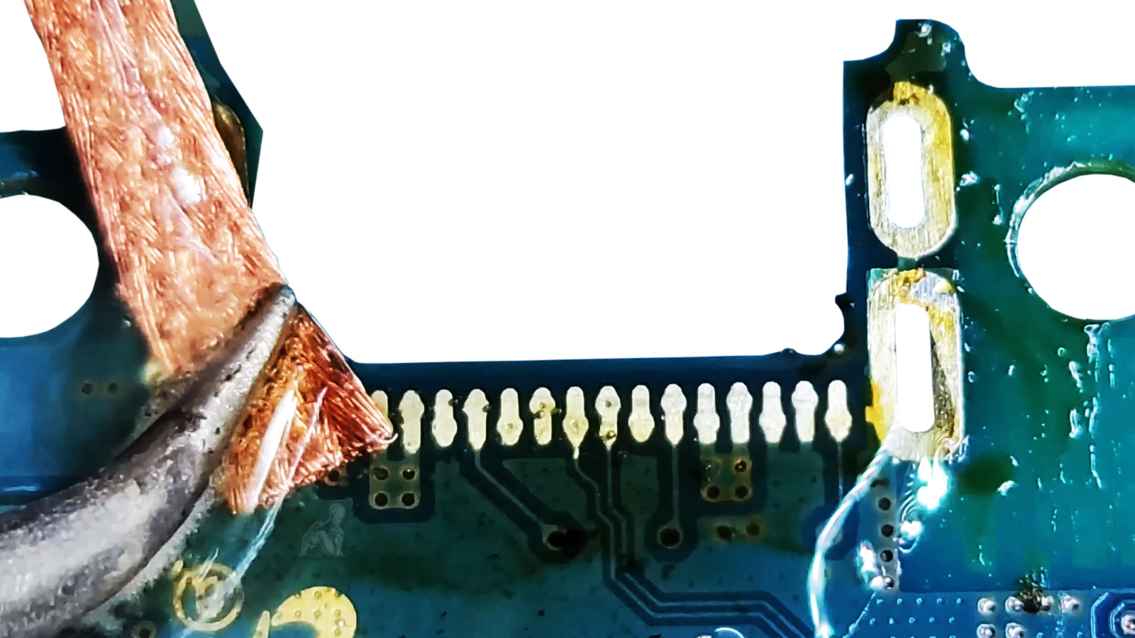 Laptop motherboard DC jack area being cleaned with solder wick and soldering iron to remove excess solder