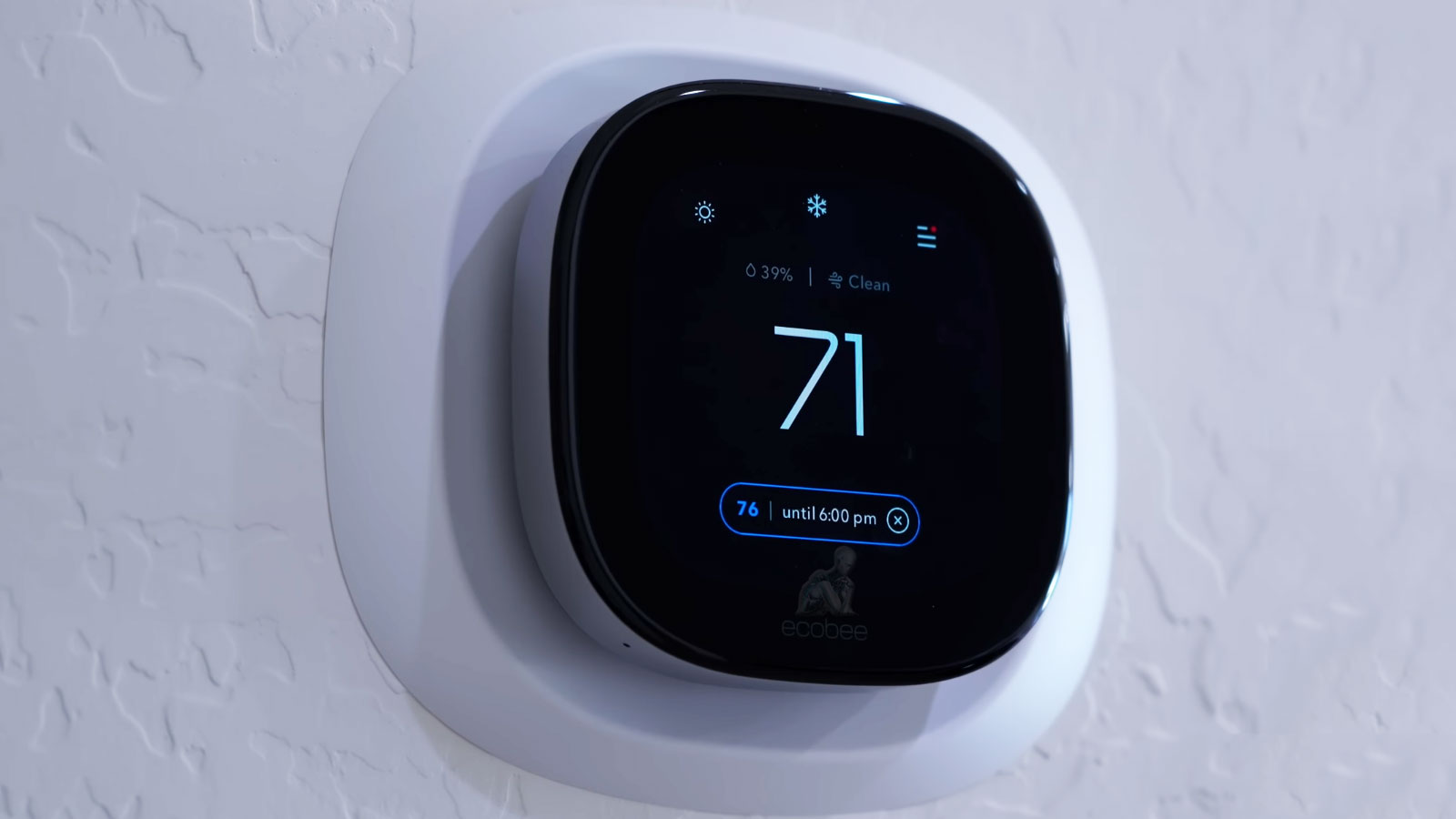 Ecobee smart thermostat mounted on wall displaying temperature and home climate settings