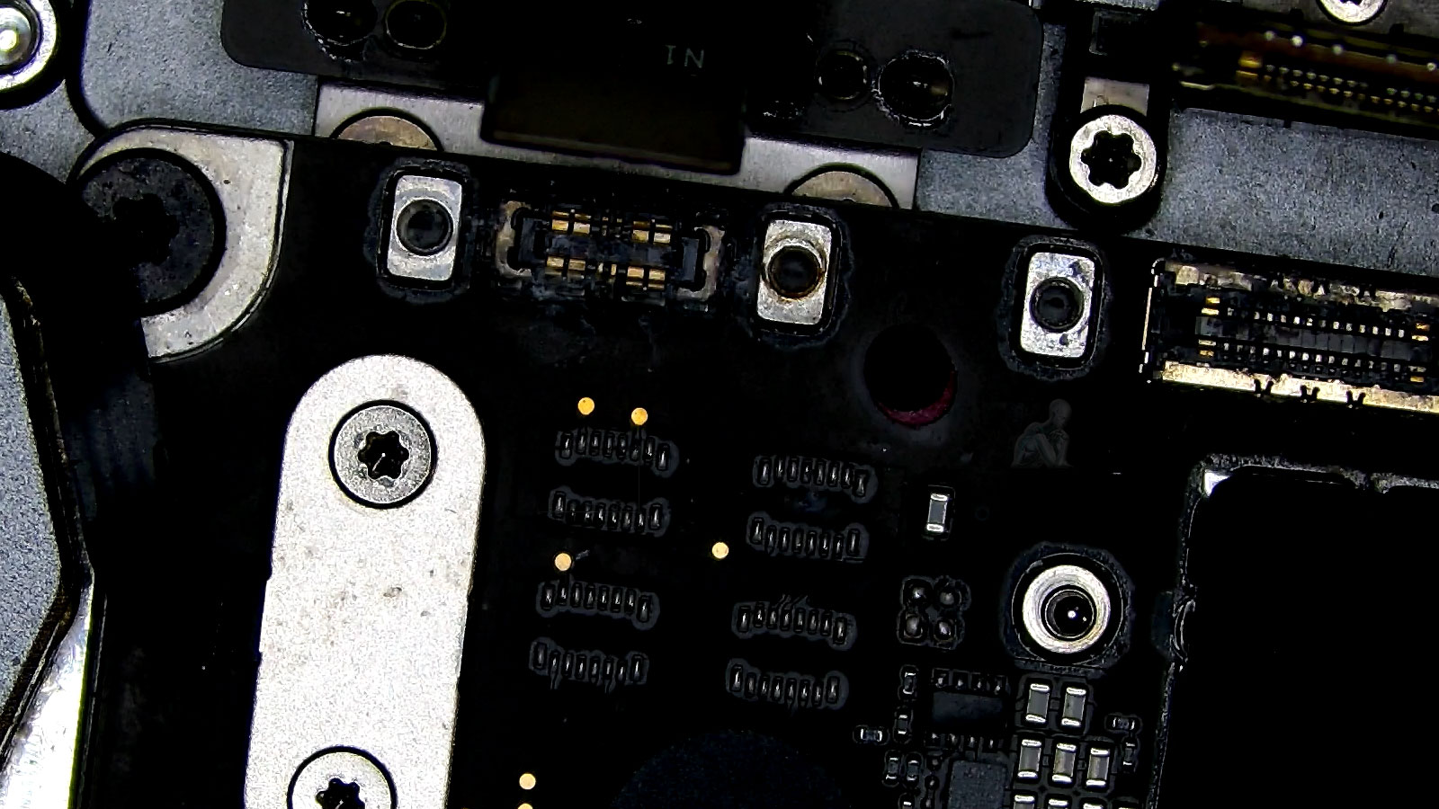 MacBook Air motherboard showing liquid damage on connectors during repair inspection in Miami