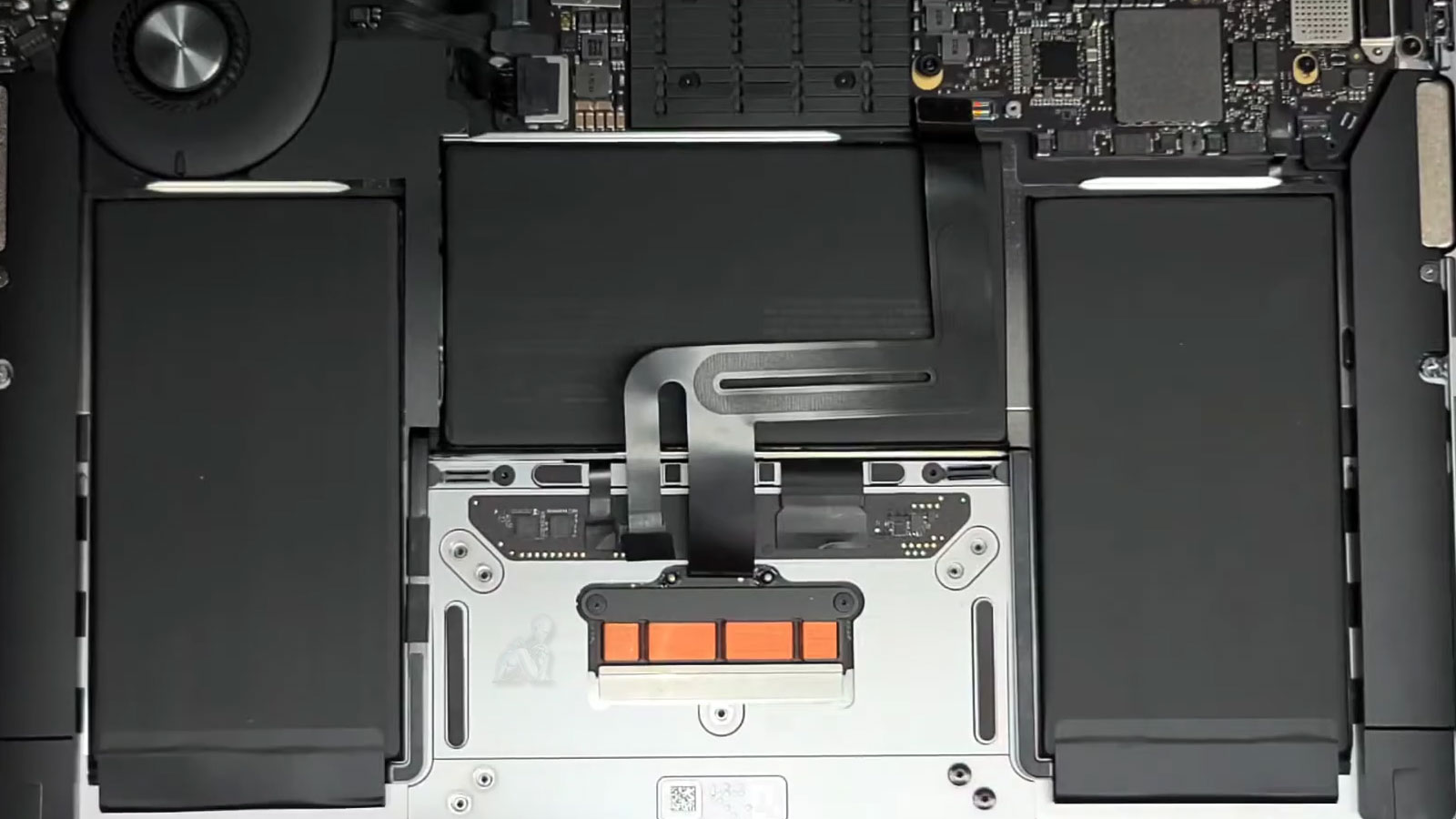 MacBook Air with back cover removed showing trackpad area during repair in Miami
