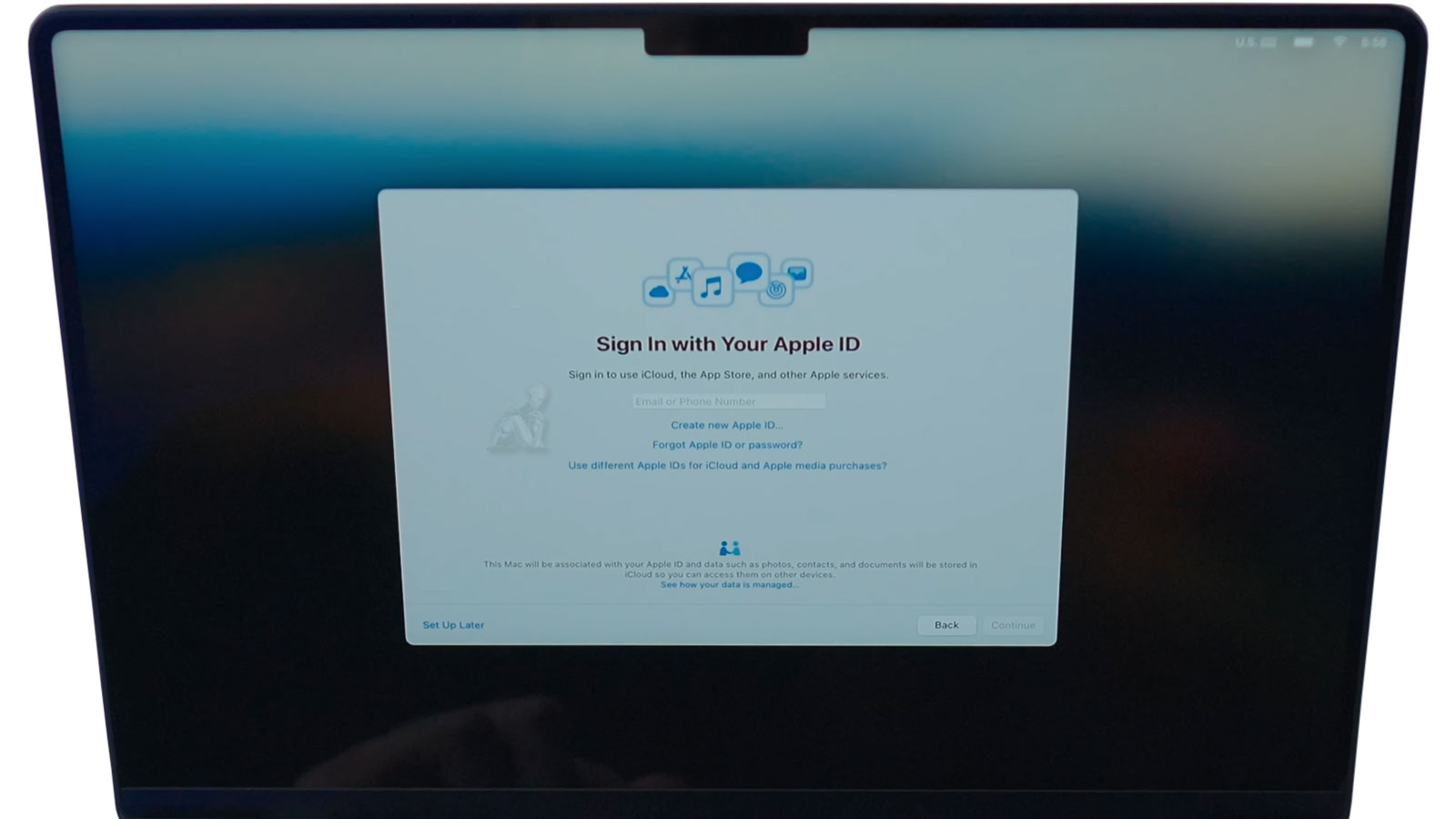 MacBook Pro screen displaying Apple ID sign-in process used during data transfer and migration