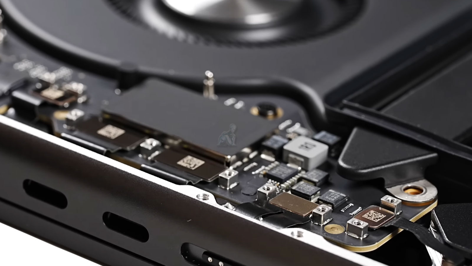 MacBook Pro opened with internal components, cooling fans, and charging port visible during repair and diagnostics in Miami