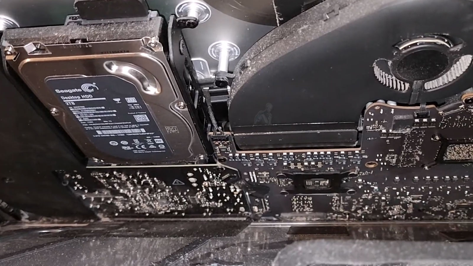 Open iMac with partially removed display showing internal 3.5 inch hard drive during data recovery process