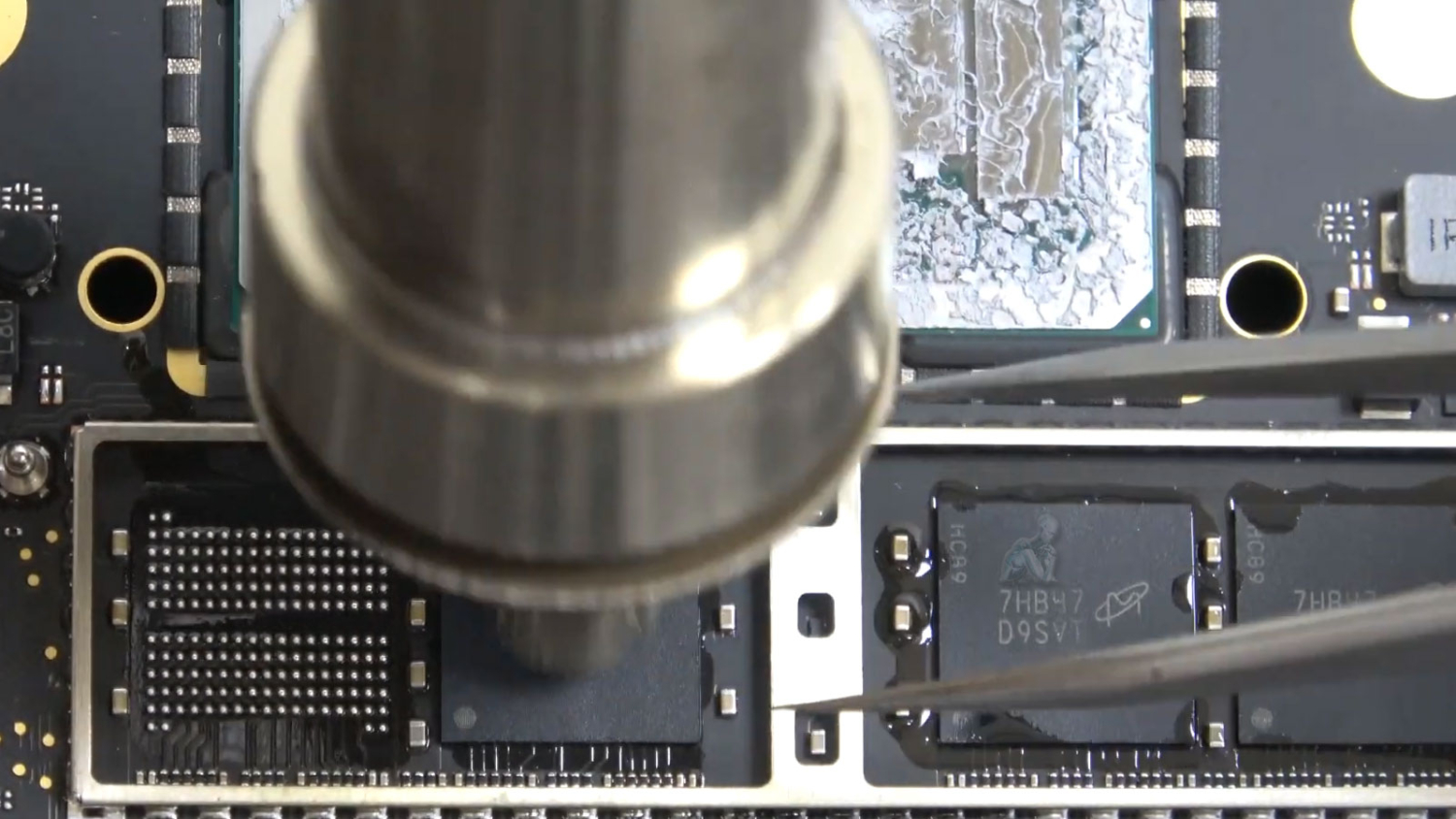 MacBook logic board with soldered RAM being removed during Mac repair in Miami
