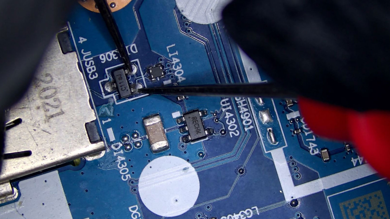 Multimeter testing a motherboard component during PC repair in Miami