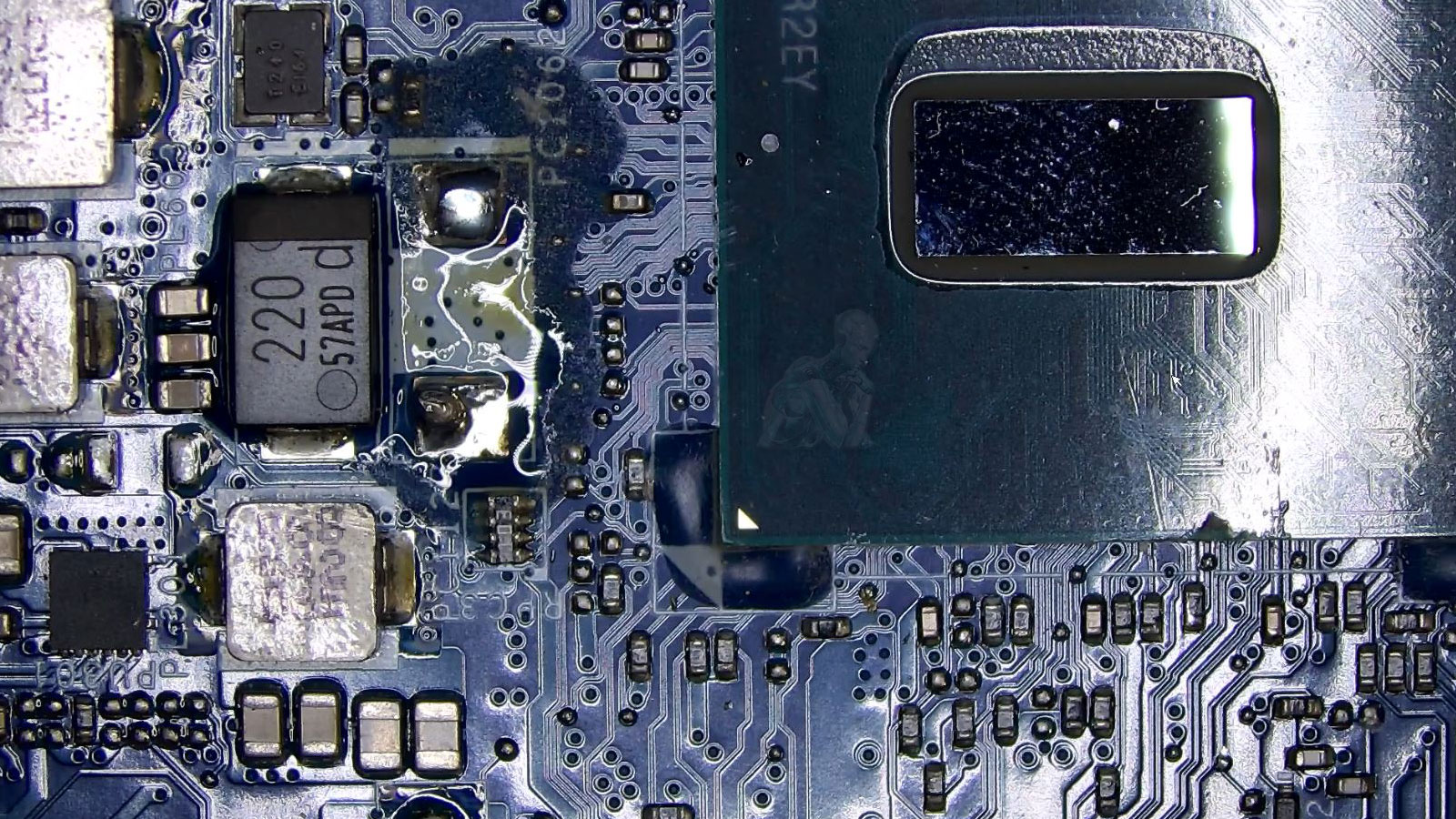 Laptop motherboard with visible liquid damage around the CPU area